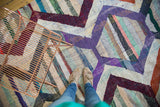 Vintage Moroccan rag rug's dense horizontal striped weave with violet, red, and ivory chevrons.