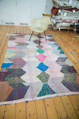 Close-up vintage rag rug, colorful diamond motif with recycled cotton texture.