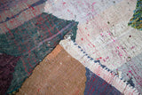 Close-up of the vintage rag rug's chunky, dense weave featuring ivory, charcoal, and bronze cotton strips.
