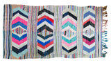 Vibrant vintage Moroccan rag rug, geometric diamonds and stripes in ivory, pink, and black.