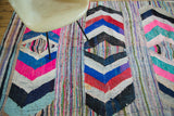 Hand woven Moroccan rag rug with hot pink, blue, red, black chevron pattern.