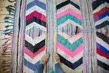 Vibrant Moroccan hand woven rag rug with hot pink, mint, black, ivory chevron patterns underfoot.