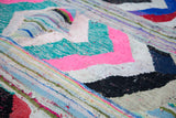 Dense texture of the recycled cotton Moroccan rag rug with geometric pink, mint, and black.