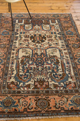 Vintage Persian Hamadan rug, ivory palmette medallion with apricot and indigo blue rolled leaves.