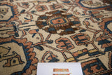 Vintage Hamadan rug showing ivory ground, chocolate, indigo, and peach sprawling leaf motifs.
