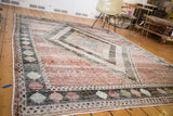 Distressed vintage Baktiari carpet, featuring a tiled diamond mosaic in muted hues.