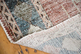 Close-up of distressed Baktiari carpet's hand-knotted back and tiled mosaic pattern.