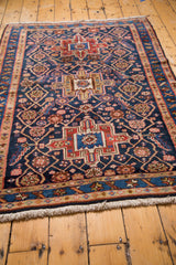 Vintage Heriz rug close-up: geometric medallion, implied lattice, fringe in indigo, red, blush.