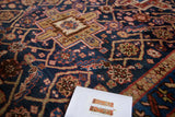 Vintage Heriz rug's indigo blue field and madder red geometric lattice pattern.