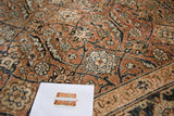 Intricate Herati motif, sickle leaves, inky blue and pale rust on an antique Tabriz rug.
