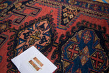 Hand-knotted vintage Persian rug with intricate geometric drawing in brick red, indigo, and gold.