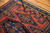 Hand-knotted vintage Persian rug's fringed end with geometric borders in indigo, brick red, sand.