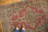 Distressed Antique Persian Tabriz rug with a pale rust salmon field, faded medallion, and ivory-navy-bronze details.