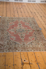 Distressed Antique Persian Tabriz rug featuring pale rust salmon field, intricate ivory and navy blooming vine patterns.