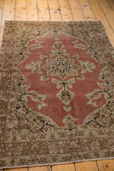 Distressed antique Persian Tabriz rug's faded rust salmon field with ivory blossoming flowers and intricate border.