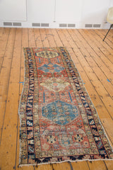 Distressed antique Heriz rug with sky blue medallion, madder red field, and blossoming flowers.