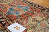 Textured distressed pile of antique Heriz runner, vibrant madder red, sky blue, and saffron.