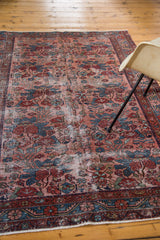 Distressed antique Lilihan rug corner, floral motifs in jewel rose and sapphire blue.