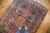 Distressed antique Shirvan rug displaying geometric animal motifs and time-softened brilliant colors.