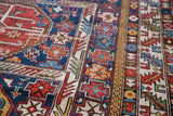 Distressed hand knotted Shirvan rug detail: geometric animal motifs in indigo, red, and ivory.