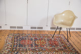 Distressed antique Shirvan rug from the Caucasus, featuring playful geometric patterns in brilliant tones.