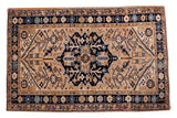 Vintage Persian Heriz rug, navy medallion on a sand field with geometric floral borders.
