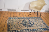 Vintage Persian Heriz rug with navy blue center medallion and alternating floral border.