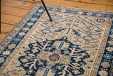 Vintage Heriz rug's navy border with pale floral designs and geometric field.