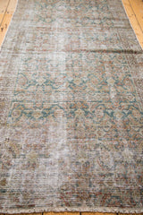 Distressed pile of an antique Malayer runner showing faded teal Herati motifs.