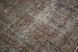 Distressed pile of antique Malayer runner, showcasing faded teal, charcoal, and ivory Herati design.