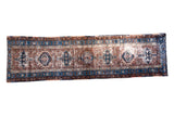 Distressed vintage Persian Karaja runner with geometric medallions in brown, blue, and ivory.