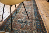 Textured detail of distressed Karaja runner, repeating medallion in faded brown and indigo.