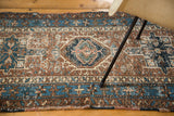 Decorative distressed texture on a blue, brown, and ivory Karaja runner border.