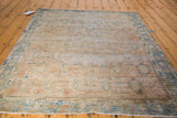 Decorative distressed Sivas rug with faded dusty rose, peach apricot, and blue patterns.