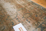 Distressed texture of a vintage Sivas rug, featuring faded dusty rose and blue patterns.