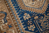 Geometric cobalt blue, ivory, and caramel pattern detail on a vintage Hamadan rug.