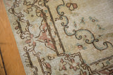 Distressed Kerman rug section revealing rococo-style motifs in muted ivory and soft pastel hues.