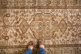 Distressed Malayer rug with central geometric medallion, showing faded peach and gold tones.