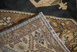 Folded corner of Vintage Sarab rug, revealing hand-knotted edge, serrated leaf border, and dark field.