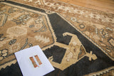 Geometric serrated leaf border and dark blue-black field with rams horn motifs on a vintage Sarab rug.
