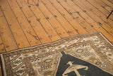 Vintage Sarab rug's bronze hexagonal medallion, dark blue-black field, and serrated leaf border.
