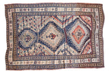 Vintage Caucasian carpet with three geometric medallions and chevron banding in navy, tangerine, and ivory.
