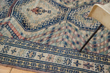 Geometric navy and ivory border with angled striping on the vintage Caucasian carpet.