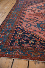 Intricate geometric border details in blush, navy, and cobalt on a vintage Malayer rug.