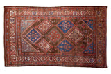 Vintage Persian Malayer rug: brown all-over diamond field, blue starbursts, and red borders.