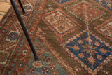 Vintage Malayer rug with brown field, cobalt starburst diamond panels, and serrated borders.