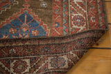 Vintage Malayer rug corner, blue starburst and red geometric pile over hand-knotted foundation.