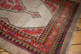 Vibrant red, softened green, blue border motifs and lattice field on a distressed Hamadan rug.