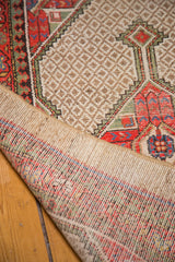 Distressed camel hair lattice field and colorful hand-knotted rug foundation.