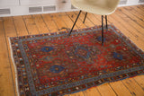 Antique Afshar rug with ruby red field, sapphire blue geometric motifs, and symbolic fish designs.